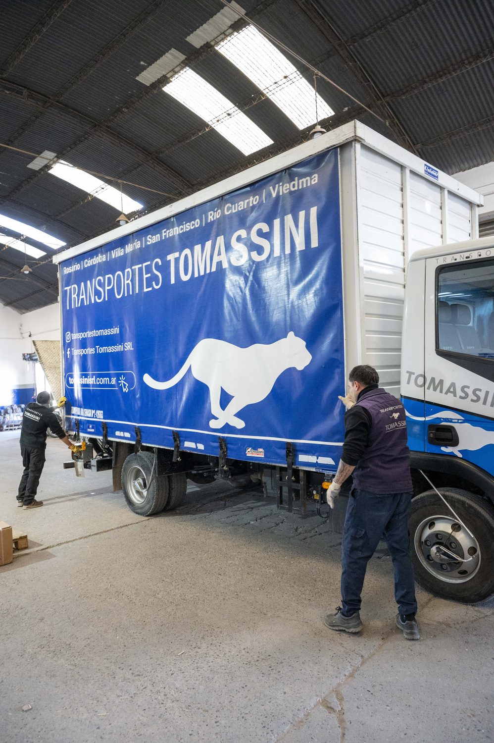 Semirremolque de Transportes Tomassini con la lona de marca, listo para cargar.