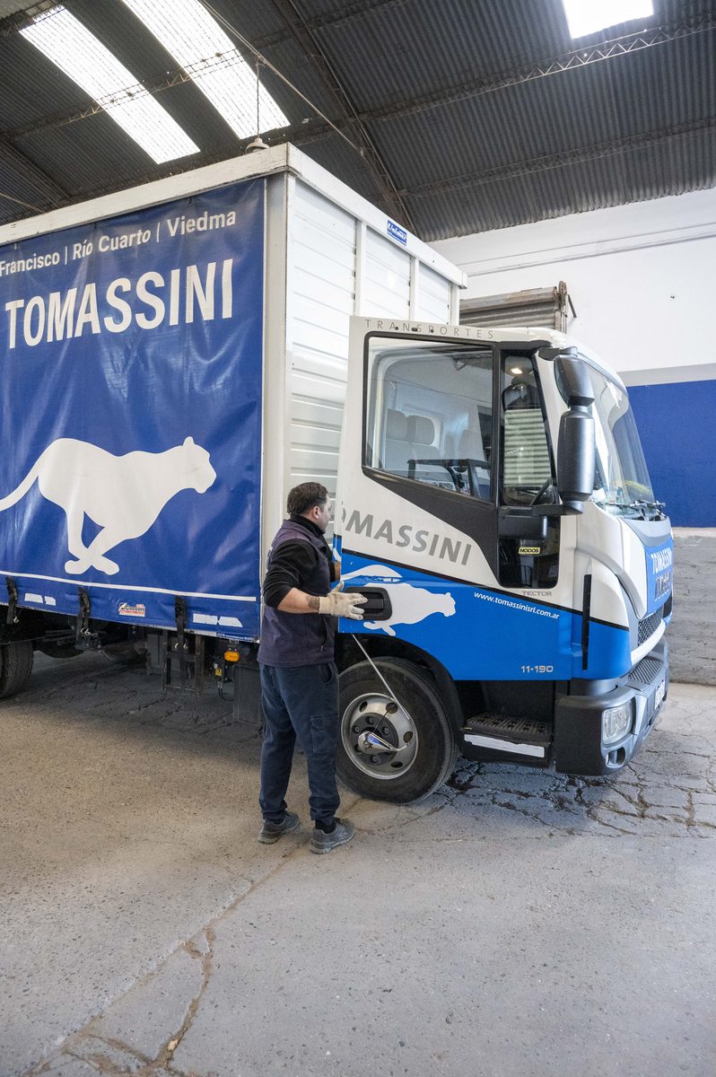 Operario de Transportes Tomassini junto a una unidad en la base.