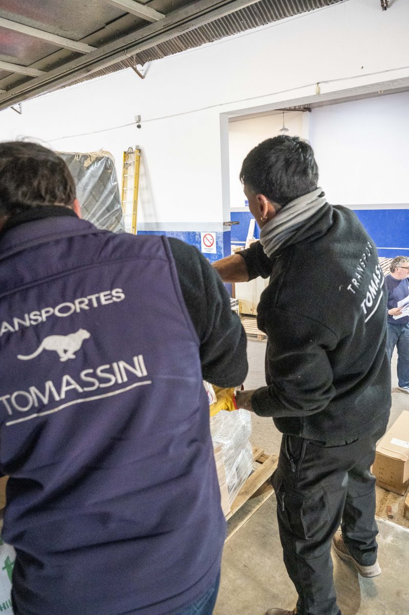 Equipo de Transportes Tomassini coordinando una carga en el depósito.